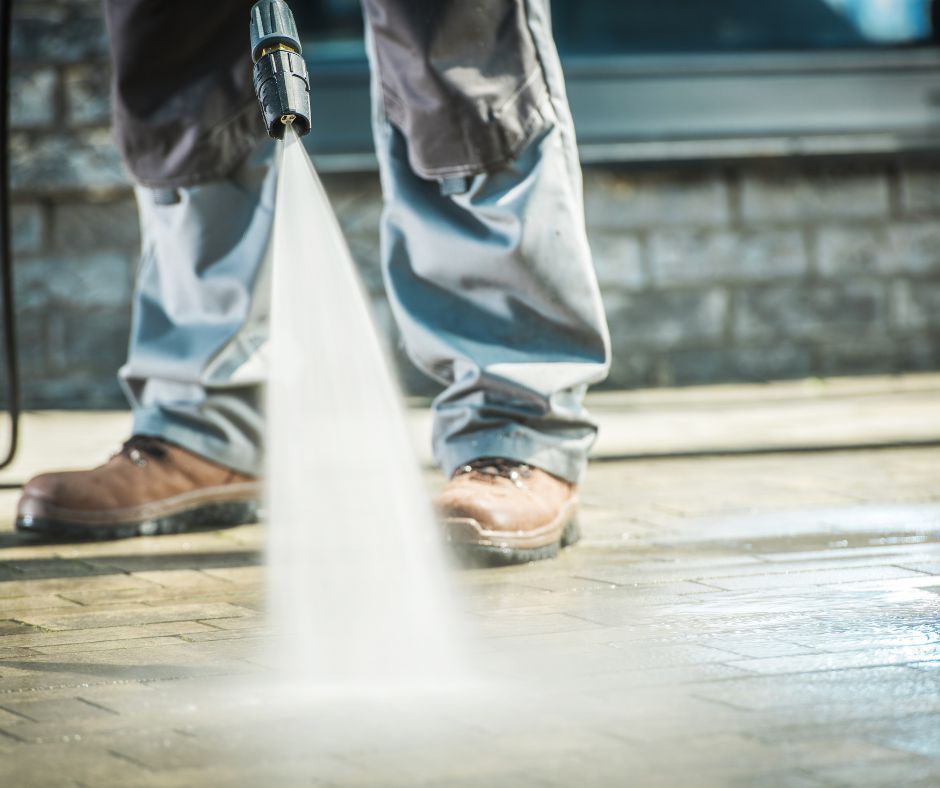 Person Using High Pressure Washing On Concrete Driveway